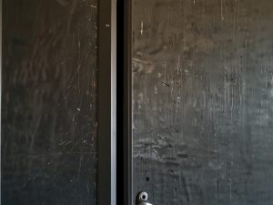 Graffi sul portone condominiale: il vandalo individuato deve essere condannato per danneggiamento o deturpamento?